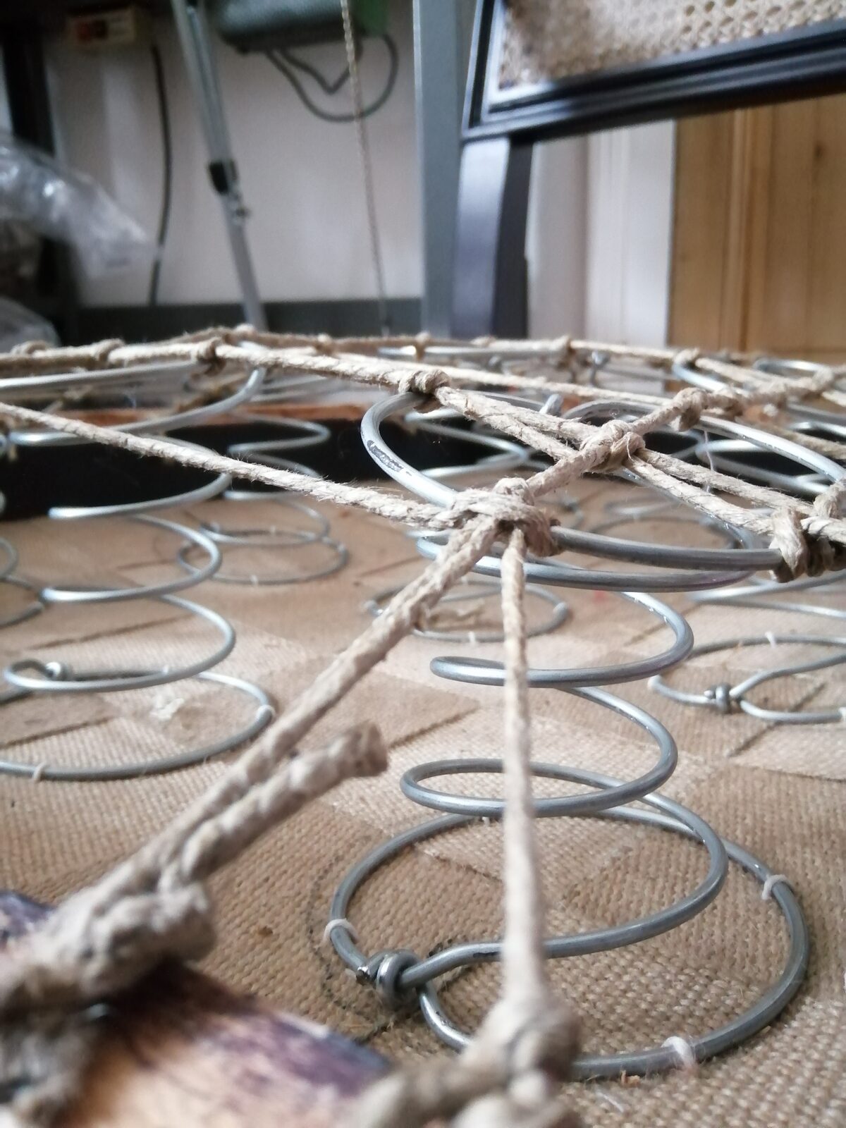 Guindage de ressorts à la ficelle de lin sur une structure de fauteuil